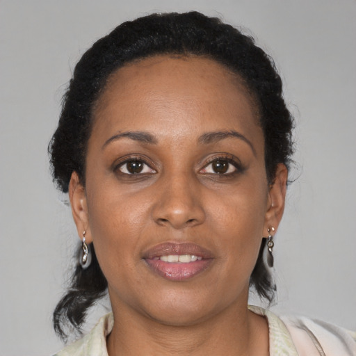 Joyful black adult female with medium  brown hair and brown eyes
