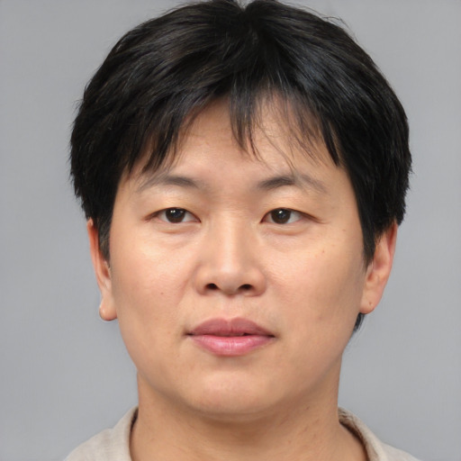 Joyful asian adult female with short  brown hair and brown eyes