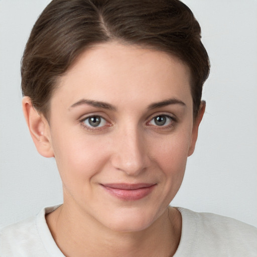 Joyful white young-adult female with short  brown hair and grey eyes