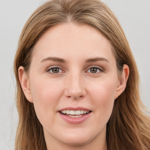 Joyful white young-adult female with long  brown hair and blue eyes