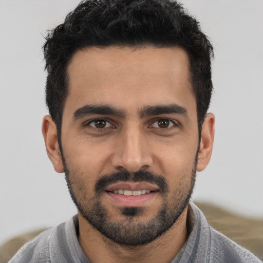 Joyful white young-adult male with short  black hair and brown eyes