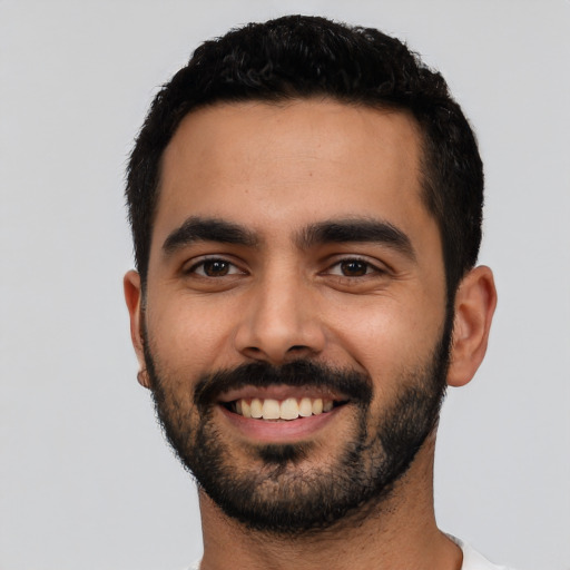 Joyful latino young-adult male with short  black hair and brown eyes