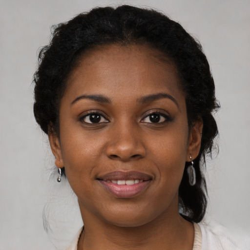 Joyful black young-adult female with short  brown hair and brown eyes