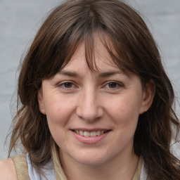 Joyful white adult female with medium  brown hair and brown eyes