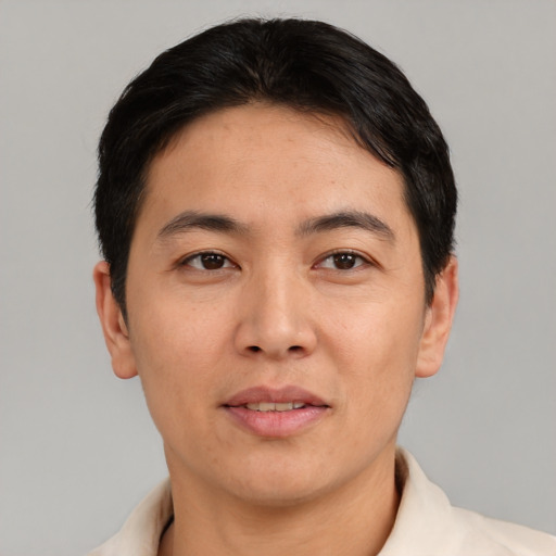Joyful asian adult male with short  black hair and brown eyes