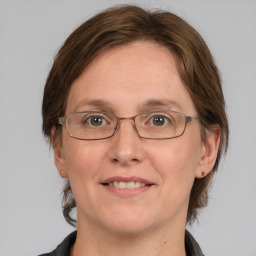 Joyful white adult female with medium  brown hair and grey eyes