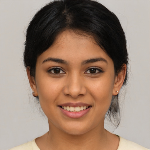 Joyful latino young-adult female with medium  brown hair and brown eyes