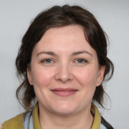 Joyful white young-adult female with medium  brown hair and grey eyes