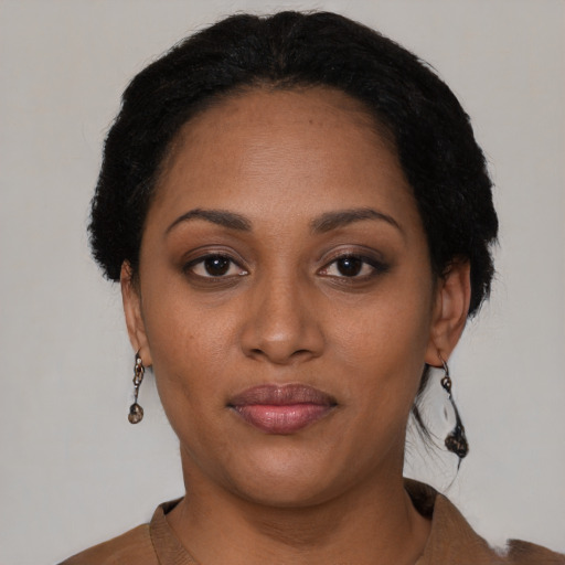 Joyful black young-adult female with short  black hair and brown eyes