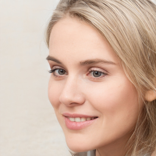 Joyful white young-adult female with long  brown hair and blue eyes