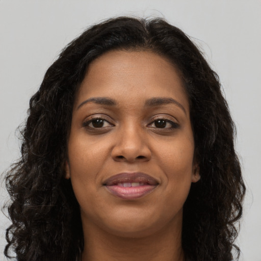 Joyful black young-adult female with long  brown hair and brown eyes