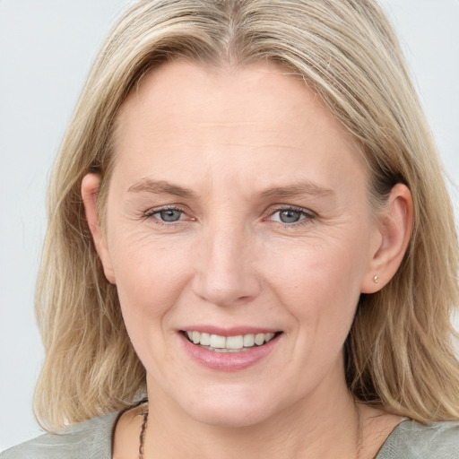 Joyful white adult female with medium  brown hair and blue eyes