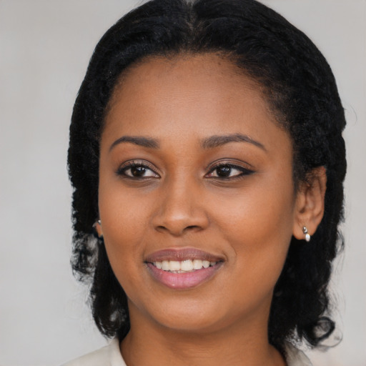 Joyful black young-adult female with long  black hair and brown eyes