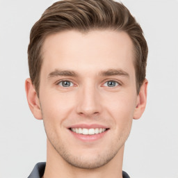 Joyful white young-adult male with short  brown hair and grey eyes