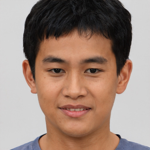 Joyful asian young-adult male with short  black hair and brown eyes