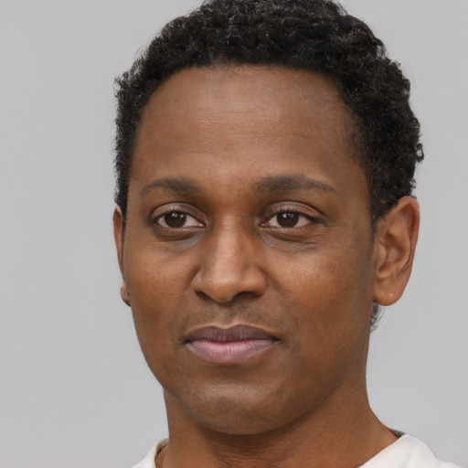 Joyful black adult male with short  brown hair and brown eyes