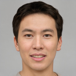 Joyful asian young-adult male with short  brown hair and brown eyes