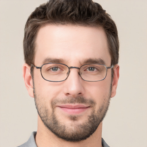 Joyful white young-adult male with short  brown hair and grey eyes