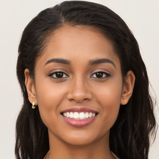 Joyful latino young-adult female with long  brown hair and brown eyes