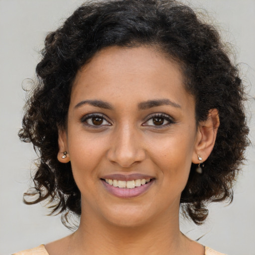 Joyful black young-adult female with medium  brown hair and brown eyes
