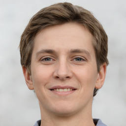 Joyful white young-adult male with short  brown hair and grey eyes