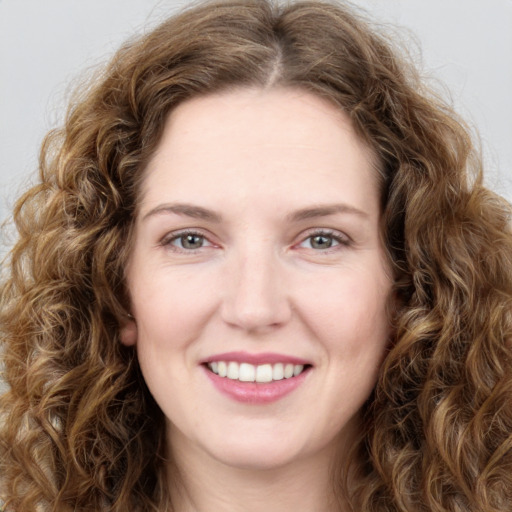 Joyful white young-adult female with long  brown hair and green eyes