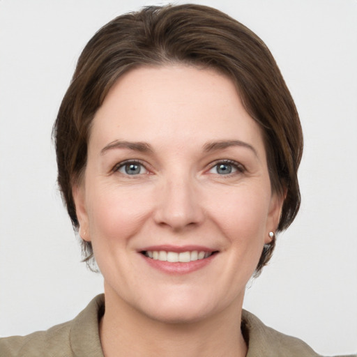 Joyful white young-adult female with medium  brown hair and grey eyes