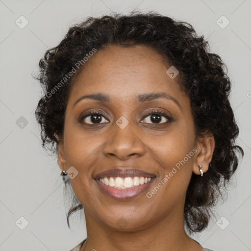 Joyful black young-adult female with long  brown hair and brown eyes