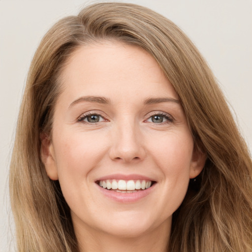 Joyful white young-adult female with long  brown hair and grey eyes