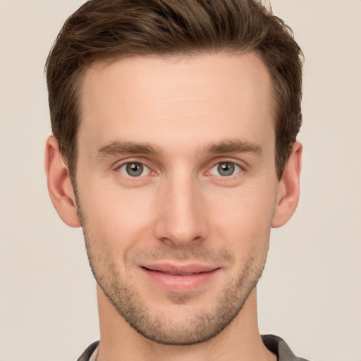 Joyful white young-adult male with short  brown hair and grey eyes