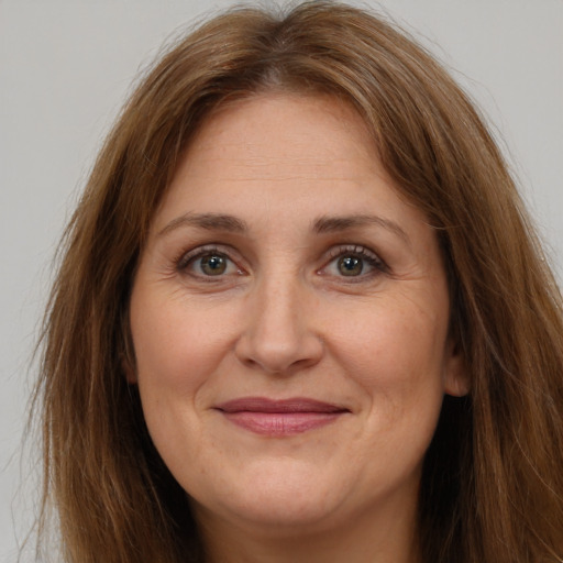 Joyful white adult female with long  brown hair and brown eyes