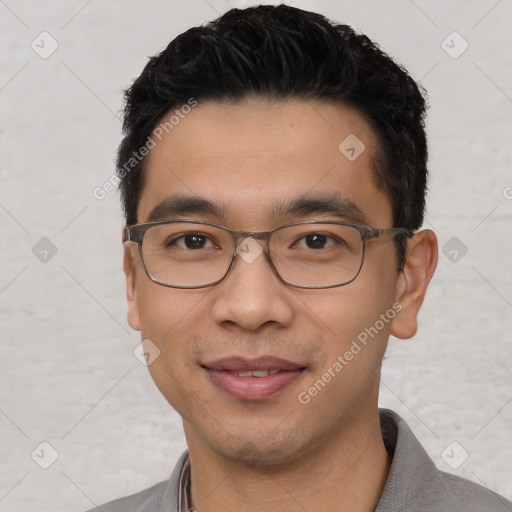 Joyful asian young-adult male with short  black hair and brown eyes