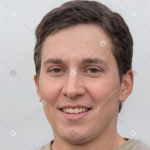 Joyful white adult male with short  brown hair and grey eyes