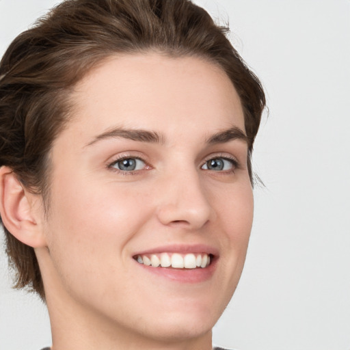 Joyful white young-adult female with short  brown hair and grey eyes