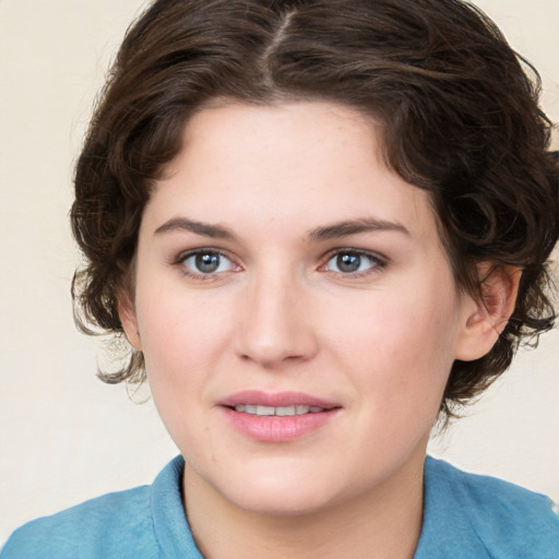 Joyful white young-adult female with medium  brown hair and blue eyes