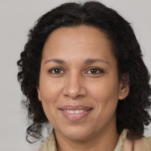 Joyful latino adult female with medium  brown hair and brown eyes