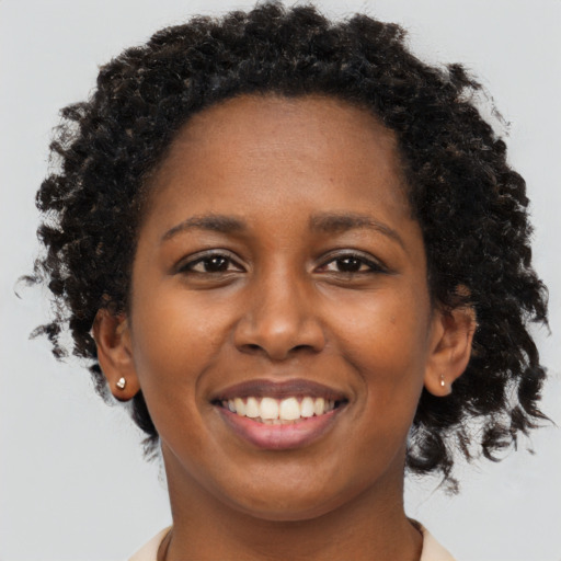 Joyful black young-adult female with short  brown hair and brown eyes