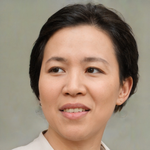 Joyful asian adult female with medium  brown hair and brown eyes
