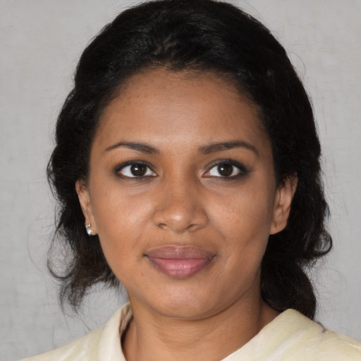 Joyful black adult female with medium  black hair and brown eyes