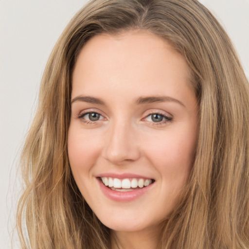 Joyful white young-adult female with long  brown hair and green eyes