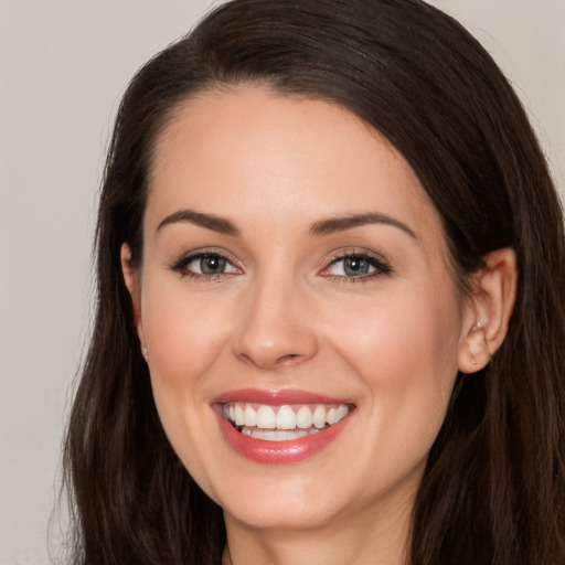 Joyful white young-adult female with long  brown hair and brown eyes