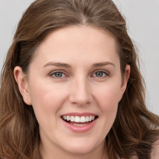 Joyful white young-adult female with long  brown hair and grey eyes