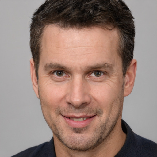 Joyful white adult male with short  brown hair and brown eyes