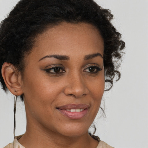 Joyful black young-adult female with short  brown hair and brown eyes
