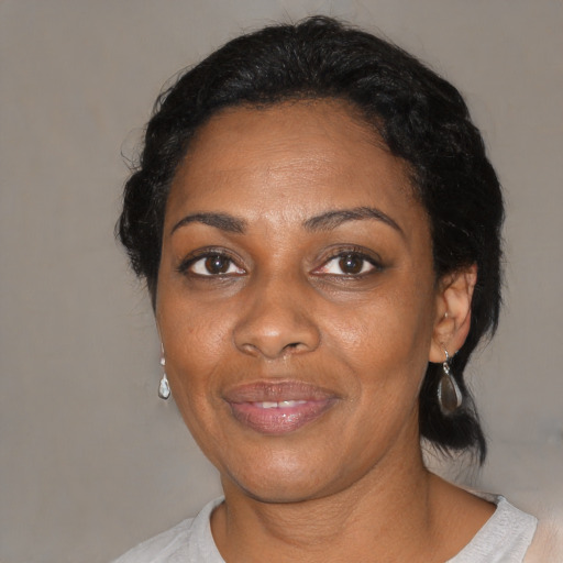 Joyful black adult female with medium  black hair and brown eyes