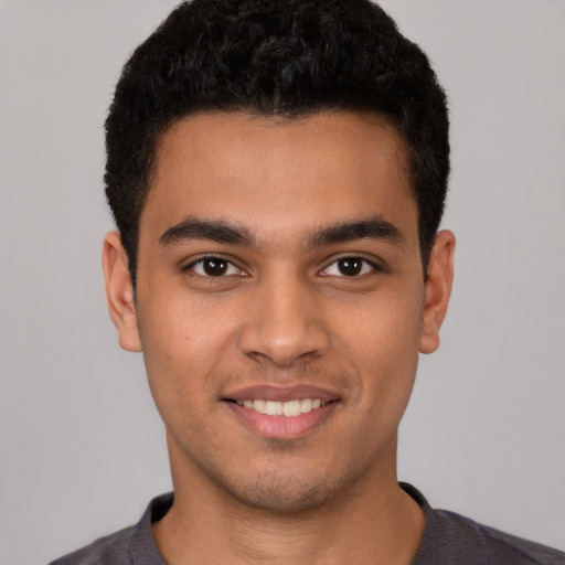 Joyful latino young-adult male with short  brown hair and brown eyes