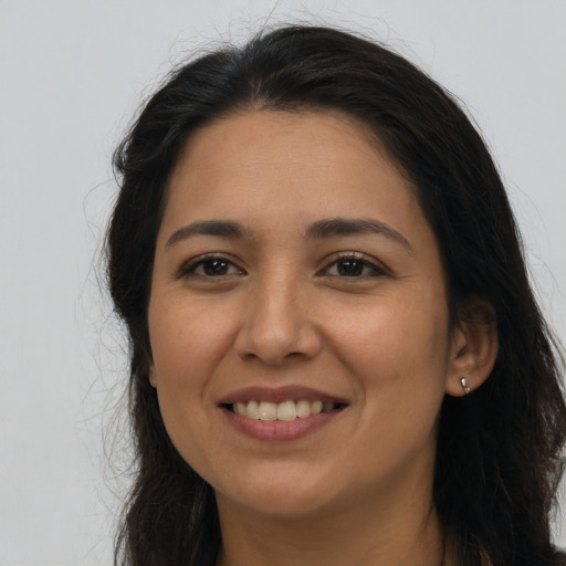 Joyful latino young-adult female with long  brown hair and brown eyes