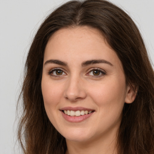 Joyful white young-adult female with long  brown hair and brown eyes