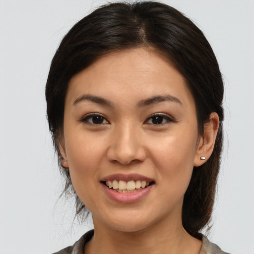 Joyful latino young-adult female with medium  brown hair and brown eyes