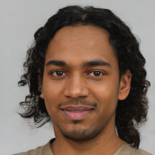 Joyful black young-adult male with medium  black hair and brown eyes